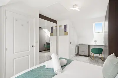 a bedroom with a white bed and a mirror at Basildon Premium Crew Stay 4 BR, Sleeps 8, Parking in Laindon