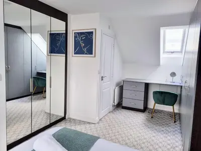 a bedroom with a desk and a chair and a mirror at Basildon Premium Crew Stay 4 BR, Sleeps 8, Parking in Laindon