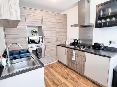 a small kitchen with a sink and a stove at Basildon Premium Crew Stay 4 BR, Sleeps 8, Parking in Laindon