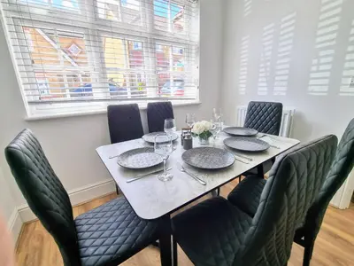 a dining room with a table and chairs at Basildon Premium Crew Stay 4 BR, Sleeps 8, Parking in Laindon