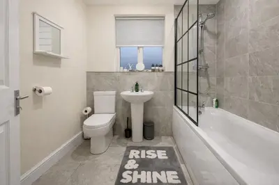 a bathroom with a sink and a toilet and a bath tub at Ipswich Hospital Accommodation, Parking & Wifi in Ipswich