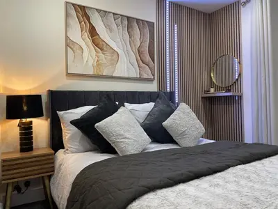 a bedroom with a bed with black and white pillows at Ipswich Hospital Accommodation, Parking & Wifi in Ipswich