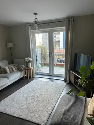 a living room with a couch and a sliding glass door at 1 bed flat close to Chelmsford City Centre in Chelmsford