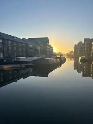 a river with buildings and a boat in the water at 1 bed flat close to Chelmsford City Centre in Chelmsford