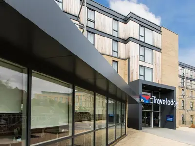 a large building with glass windows in front of it at Travelodge Cambridge Newmarket Road in Chesterton