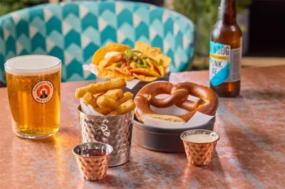 a table with a tray of onion rings and a basket of food at Travelodge Cambridge Orchard Park in Milton