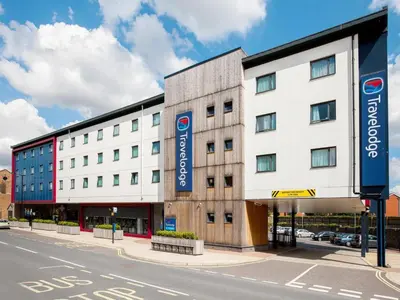 a large white building on the corner of a street at Travelodge Ipswich in Ipswich