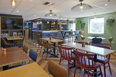 a restaurant with tables and chairs and a bar at Travelodge Chelmsford in Chelmsford