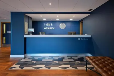 a waiting room with a blue wall and a bench at Travelodge Harlow in Harlow