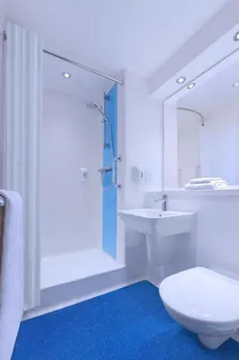 a white bathroom with a toilet and a sink at Travelodge Haverhill in Haverhill