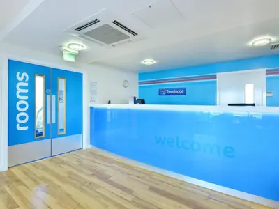 a waiting room with a blue welcome wall at Travelodge Haverhill in Haverhill