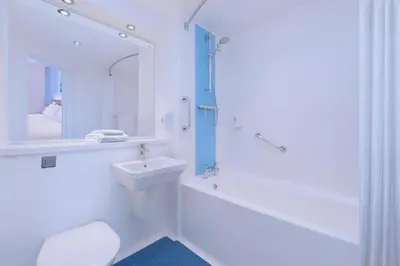 a bathroom with a sink and a toilet and a bath tub at Travelodge Haverhill in Haverhill