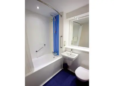 a bathroom with a sink and a tub and a toilet at Travelodge Ipswich Beacon Hill in Needham Market