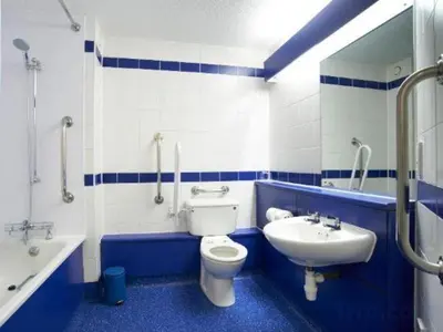 a blue and white bathroom with a toilet and a sink at Travelodge Ipswich Beacon Hill in Needham Market