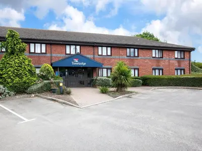 a large red brick building with a parking lot at Travelodge Ipswich Capel St Mary in Capel Saint Mary