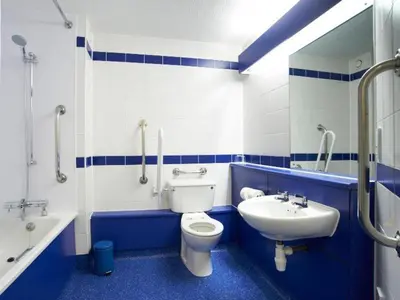 a blue and white bathroom with a toilet and a sink at Travelodge Ipswich Capel St Mary in Capel Saint Mary