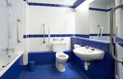 a blue and white bathroom with a toilet and a sink at Travelodge Ipswich Capel St Mary in Capel Saint Mary