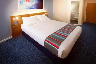 a bedroom with a large white bed in a room at Travelodge Cambridge Swavesey in Bar Hill