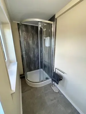 a shower in a bathroom with a glass shower stall at The old greengrocers Battlesbridge in Rawreth