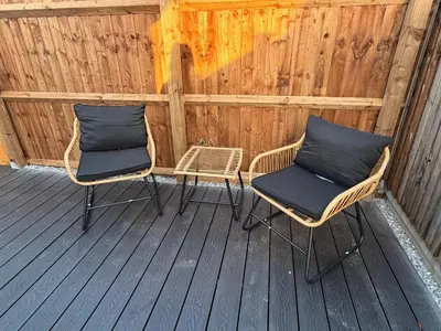 two wicker chairs sitting on a wooden deck at The old greengrocers Battlesbridge in Rawreth
