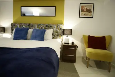 a bedroom with a bed and a yellow chair at Central Location Stylish 1-Bed Apartment Free Parking in Colchester
