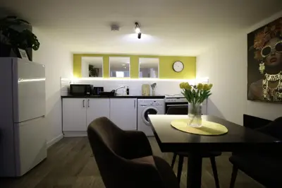 a kitchen and dining room with a table with flowers on it at Central Location Stylish 1-Bed Apartment Free Parking in Colchester