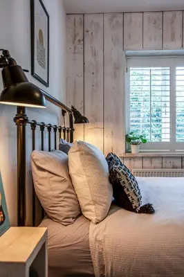 a bedroom with a bed with pillows and a lamp at Blackshore House in Wenhaston