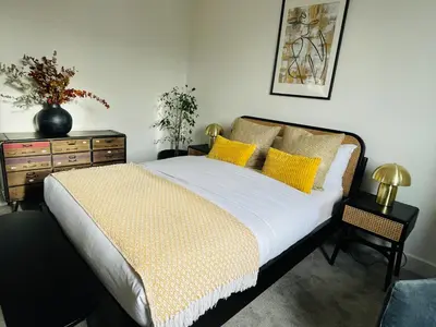 a bedroom with a bed with yellow pillows and a dresser at Cozy Organic Tea House in Central Ipswich near Waterfront, University and Hospital in Ipswich