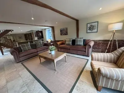 a living room with couches and a coffee table at Stunning converted barn - Brand sleeps 8 in Sutton