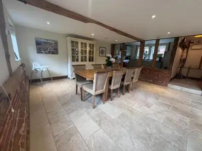 a dining room with a wooden table and chairs at Stunning converted barn - Brand sleeps 8 in Sutton