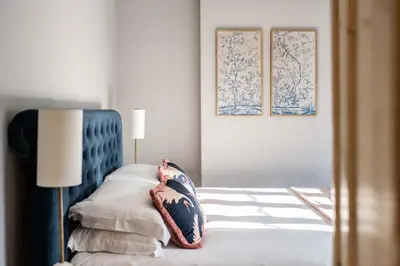 a bedroom with a bed with a blue headboard at Bressingham Lodge by Leap Escapes in Diss
