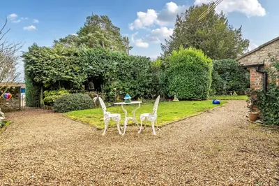 two chairs and a table in a garden at Old Rectory Cottage, Tostock in Tostock