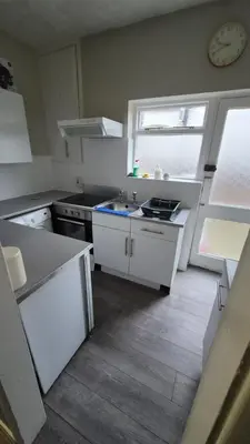 a kitchen with a sink and a stove and a window at Happy house in Southend-on-Sea
