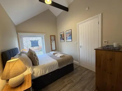a bedroom with a bed with a window and a lamp at Well-Connected One Bedroom Self-Contained Rural Retreat in Chelmsford