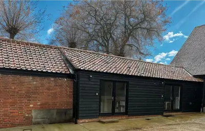 a black building with a brick wall at Well-Connected One Bedroom Self-Contained Rural Retreat in Chelmsford