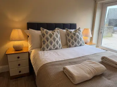 a bedroom with a bed with pillows and a window at Well-Connected One Bedroom Self-Contained Rural Retreat in Chelmsford