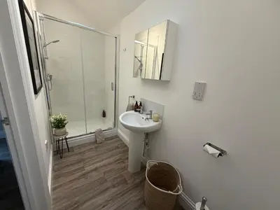 a white bathroom with a sink and a shower at Well-Connected One Bedroom Self-Contained Rural Retreat in Chelmsford