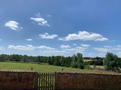 a brick fence with a field in the background at Well-Connected One Bedroom Self-Contained Rural Retreat in Chelmsford