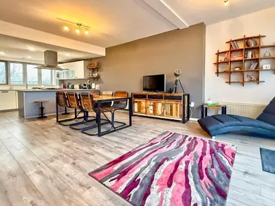 a living room with a table and a couch at Split level unique large 2BDR apartment in Chelmsford