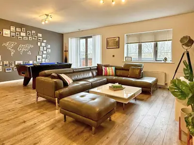 a living room with a couch and a pool table at Split level unique large 2BDR apartment in Chelmsford