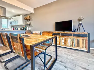 a dining room with a table and a tv at Split level unique large 2BDR apartment in Chelmsford