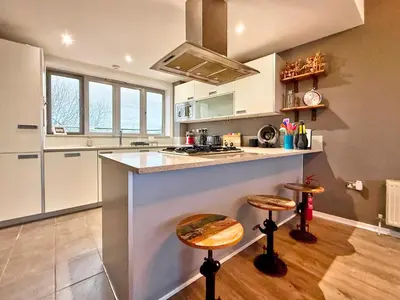 a kitchen with a counter and two stools at Split level unique large 2BDR apartment in Chelmsford