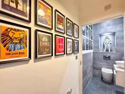 a bathroom with framed pictures on the wall at Split level unique large 2BDR apartment in Chelmsford