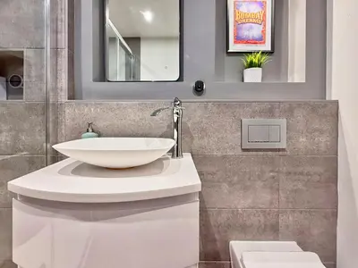 a bathroom with a white sink and a mirror at Split level unique large 2BDR apartment in Chelmsford
