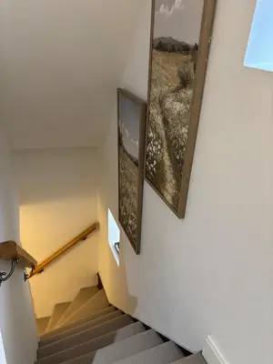 a staircase with two framed pictures on the wall at 7 The Quay in St Ives