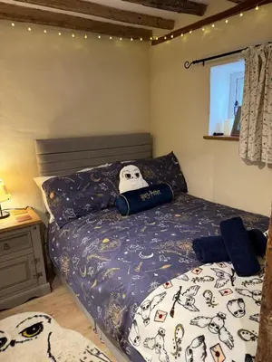 a bedroom with a bed with a skull pillow on it at Cosy Flint Cottage in Thurston
