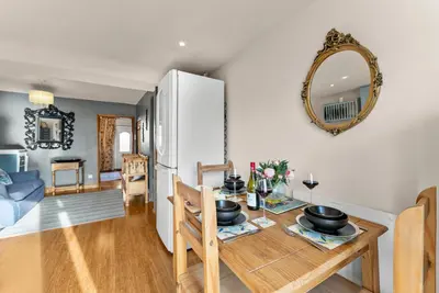 a kitchen and living room with a table and a refrigerator at Abbey House- Character filled 1 bed- sleeps 4 in Bury Saint Edmunds