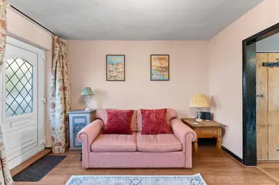 a living room with a pink couch and a table at Abbey House- Character filled 1 bed- sleeps 4 in Bury Saint Edmunds