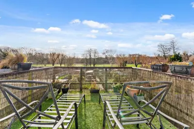 two chairs sitting in the grass next to a fence at Abbey House- Character filled 1 bed- sleeps 4 in Bury Saint Edmunds