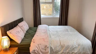 a bed in a bedroom with a window at Cozy Guest Room in Basildon with Shared Facilities in Basildon